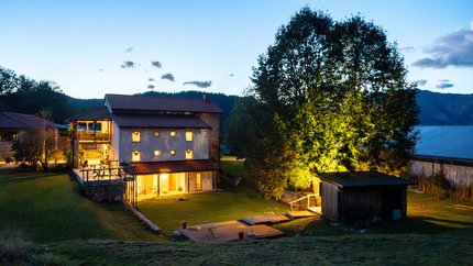 REST AND RIDE © Ziga Koren Haus mit beleuchtetem Garten bei Dämmerung in einer ländlichen Umgebung