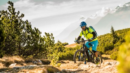 Tramin © TV Tramin - Antie Braito Man mountain biking on a trail with mountains in the background
