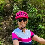 Mountain Bike Holidays © Hotel Sonnblick GmbH Frau mit Helm neben Mountainbike auf Waldweg