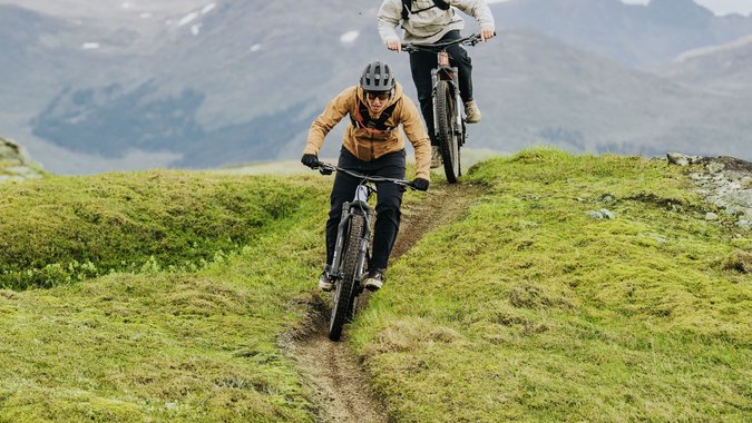 Mountain Bike Holidays © Bosch eBike Systeme Zwei Mountainbiker fahren auf einem schmalen Pfad in bergigem Gelände