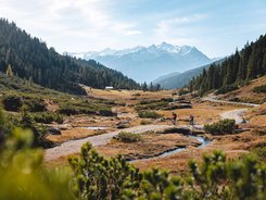 Kitzbühel Alps - Brixental Valley © TVB Kitzbüheler Alpen - Brixental - Mathäus Gartner Two cyclists on a mountain trail with snow-capped peaks in the background