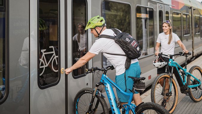 Mountain Bike Holidays © TV Niederdorf - Manuel Kottersteger Personen mit Fahrrädern warten auf Zug mit Fahrradabteil