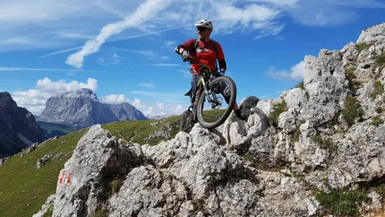GARDENA RONDA © Hotel Digon St. Ulrich Mountain biker with helmet on rocky mountain trail with mountain backdrop