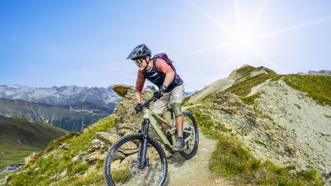 Mountain Bike Holidays © TVB Paznaun-Ischgl Mountainbiker fährt auf schmalem Bergpfad bei sonnigem Wetter