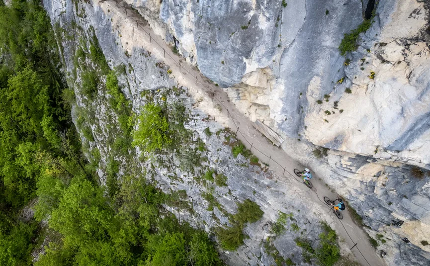Mountain bike holiday in the Salzkammergut © Bikeboard.at - Erwin Haiden Two cyclists on narrow mountain trail next to cliff with dense green forest