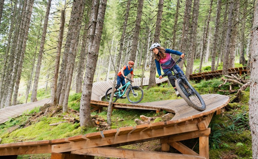 Mountain biking in Salzburger Land © Patrick Wasshuber Two mountain bikers riding on a wooden trail in the forest