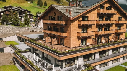 Paradise Lodge Modern wooden hotel with pool and green mountains in the background