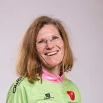 Mountain Bike Holidays © WOM Medien Lächelnde Frau in Mountainbike-Trikot und Jeans vor hellem Hintergrund