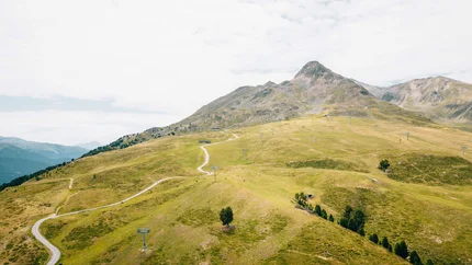 Piz Trail © Patrick Wasshuber Green mountain landscape with trails and chairlifts under cloudy sky