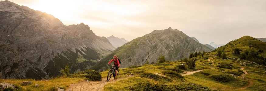 Livigno © Christoph Gramann Cyclist riding mountain trail at sunset in the Alps
