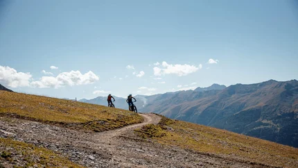 Zirmtrail © Felix Saller Two mountain bikers riding on a mountain trail under clear sky