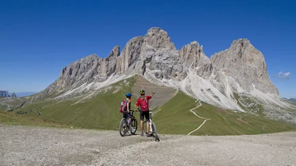PRALONGIA TOUR © Hotel Pider Two cyclists with mountain bikes looking at the Dolomite mountains