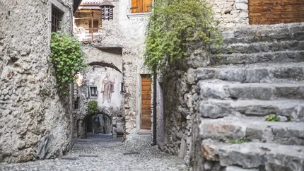 San Giovanni al Monte © APT Garda Dolomiti Narrow cobblestone path with stairs and mural in an old village