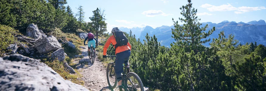 Alta Badia © Tobias Köhler Two mountain bikers riding on a sunny mountain trail