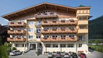 Hotel Almhof Lackner © Almhof Lackner GmbH Hotel mit Blumenschmuck an Balkonen und Autos vor dem Eingang