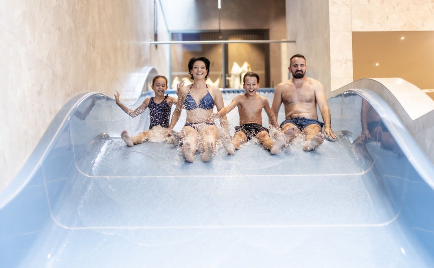 Alpen Hotel Post **** Family sliding together down a water slide at the pool