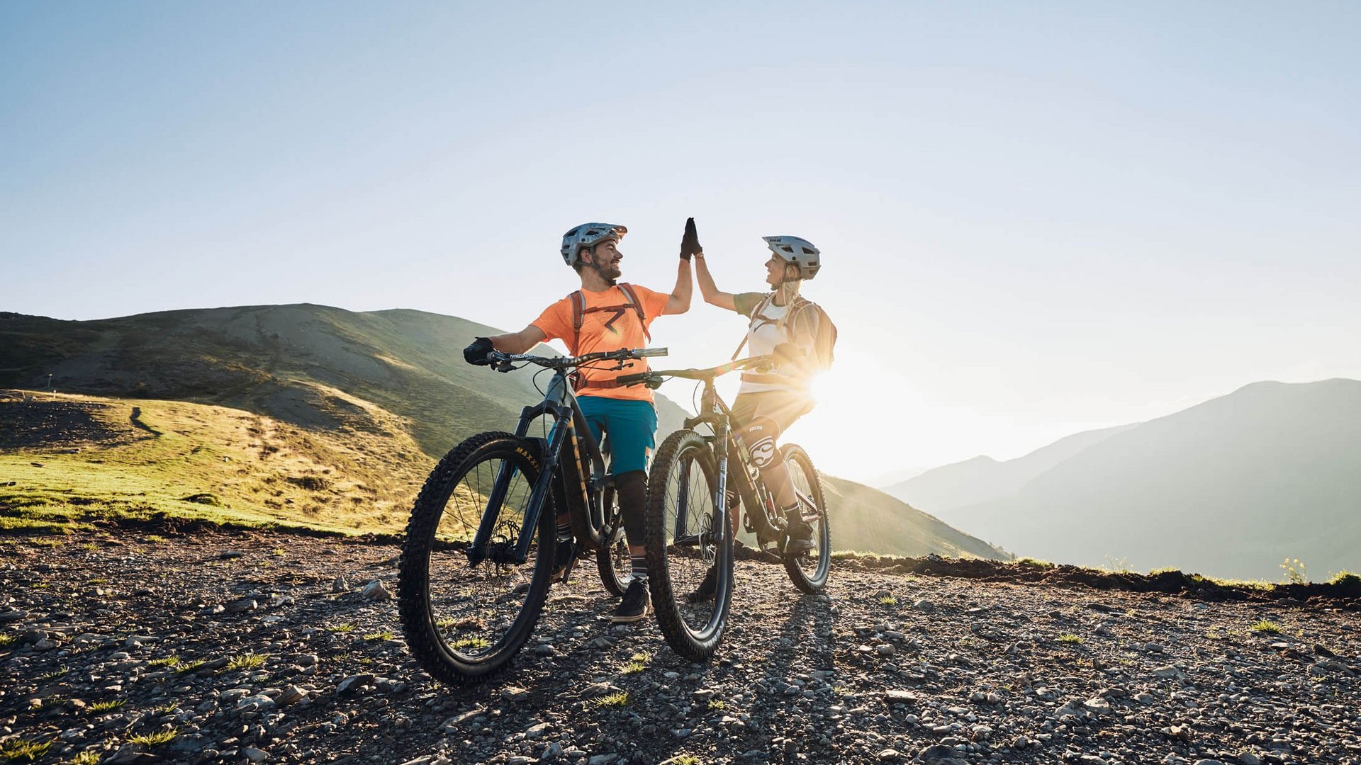 Mountain Bike Holidays © Tobias Köhler Zwei Radfahrer geben sich beim Mountainbiken in den Bergen einen Highfive