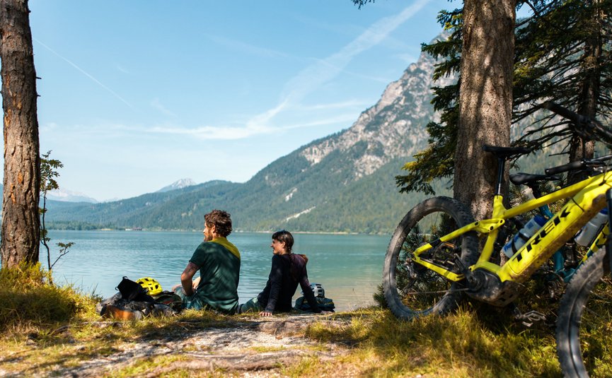 Mountain bike holidays in the Tiroler Zugspitz Arena © David Karg Two cyclists sitting by a lake with mountains in the background