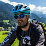 Mountain Bike Holidays © MonEpic Gruppe von Radfahrern auf einem Landweg in grüner Berglandschaft