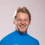 Mountain Bike Holidays © Hotel Klausen Lächelnder Mann in blauem Mountain Bike Trikot vor neutralem Hintergrund