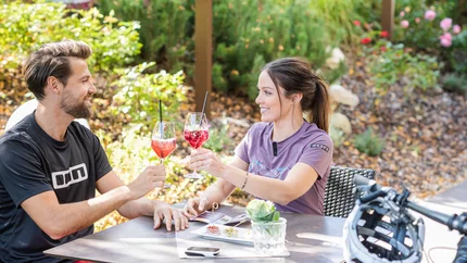 Lercher Alm & Earth Pyramids Couple toasting with drinks at outdoor garden cafe
