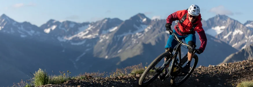 Livigno © Samuel Confortola Mountain biker riding on a mountain trail with alpine peaks in the background