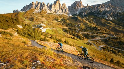 DOLOMITES Val Gardena © David Karg Two mountain bikers on trail in mountainous landscape with rocky peaks