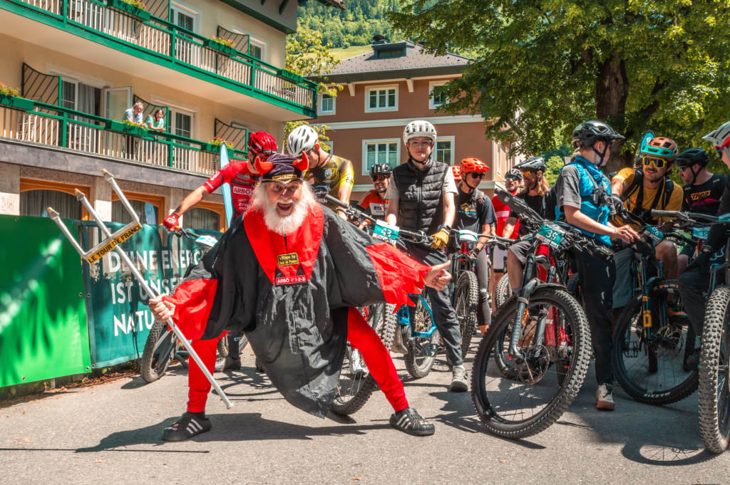 Nockbike-Trophy Hit Man in devil costume posing in front of cyclists at an outdoor event