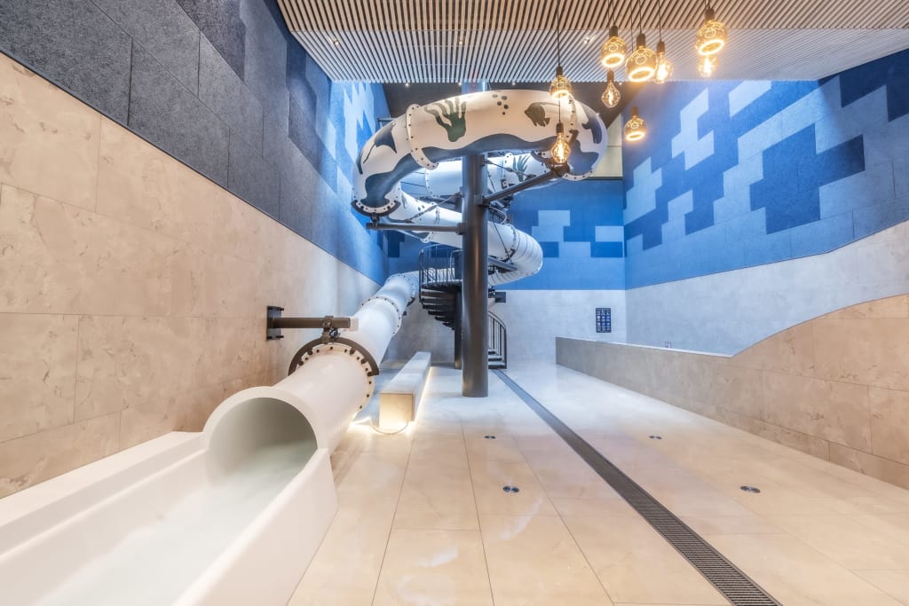 Dwarfweek Modern indoor slide in a blue and beige room with spiral staircase